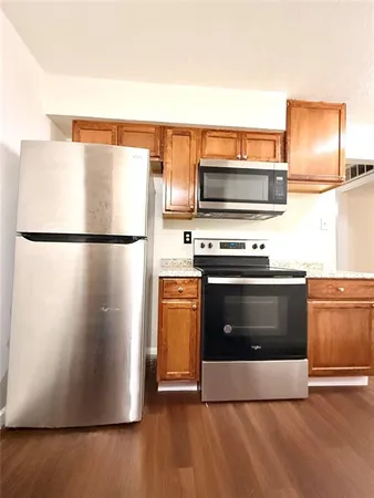 a kitchen with wooden cabinets and a stainless steel refrigerator stove