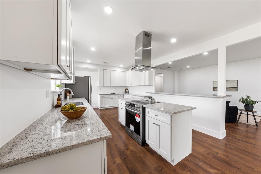 1128 Newton Road Ferris, TX 75125 - Photo 10 of 28 Modern kitchen featuring white cabinetry, light-toned countertops, a stainless steel range hood, and wood-finish flooring