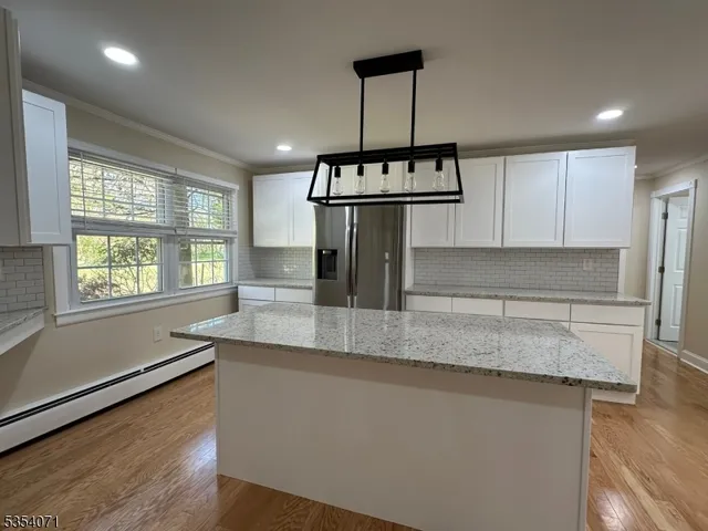 a kitchen with stainless steel appliances granite countertop a sink a refrigerator and a granite counter tops