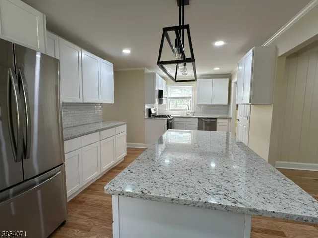 a kitchen with stainless steel appliances granite countertop a sink refrigerator and microwave