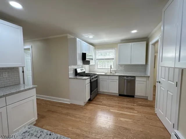 a kitchen with a refrigerator stove top oven and sink