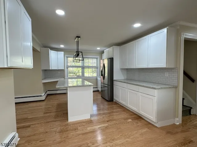 a kitchen with granite countertop white cabinets and white appliances