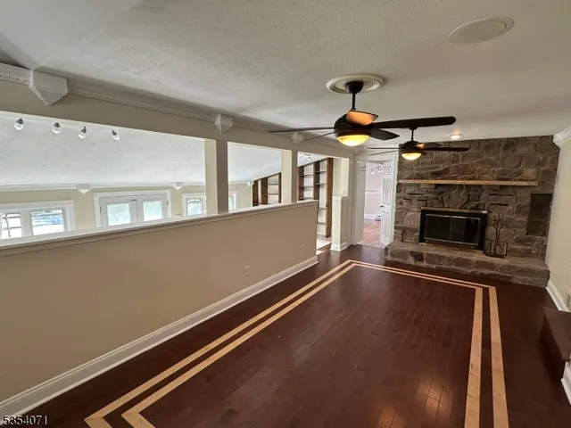 a room with wooden floor fireplace and windows