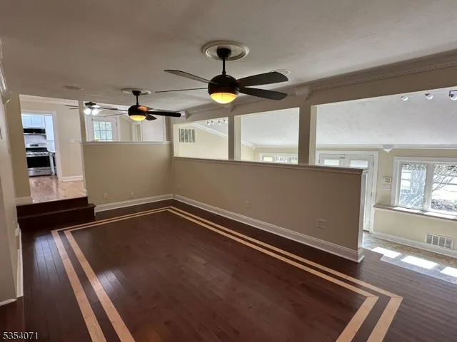 a view of an empty room with wooden floor