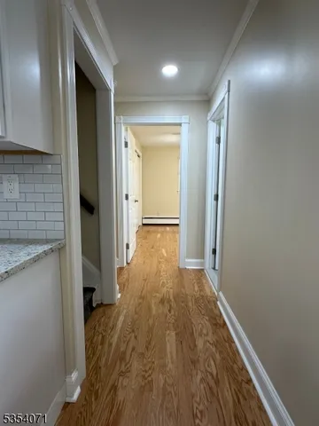 a view of hallway with wooden floor