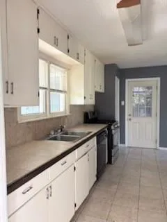 a kitchen with a sink cabinets and window