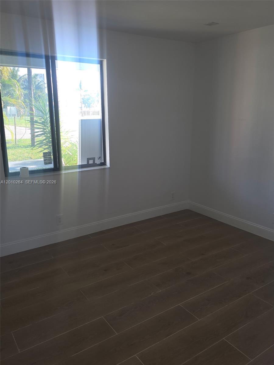 3300 Southeast 6th Street, Unit 2 Pompano Beach, FL 33062 - Photo 2 of 7 an empty room with wooden floor and windows