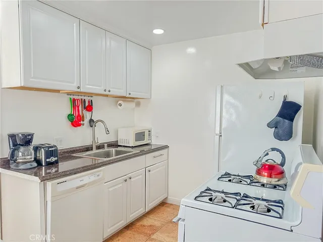 a kitchen with white cabinets and white appliances