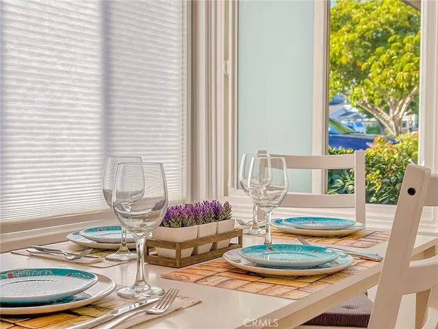 a dining room with table and chairs and potted plants