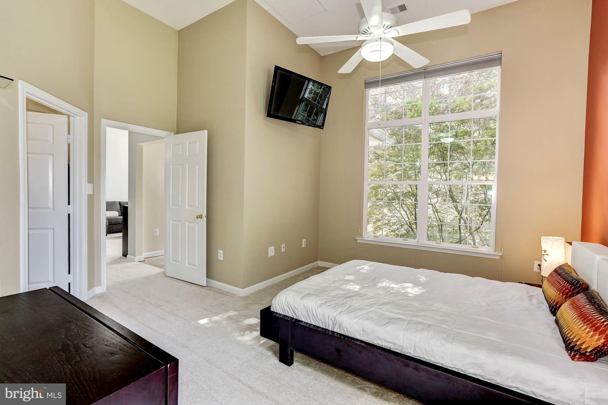 11408 Gate Hill Place, Unit 116 Reston, VA 20194 - Photo 11 of 28 a bedroom with a bed and a flat screen tv