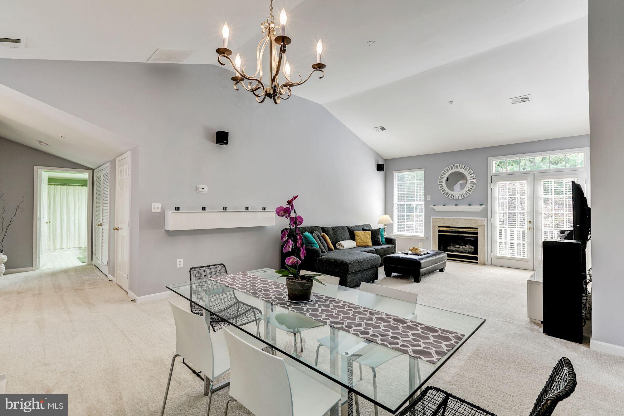 11408 Gate Hill Place, Unit 116 Reston, VA 20194 - Photo 3 of 28 a living room with furniture a fireplace and a chandelier