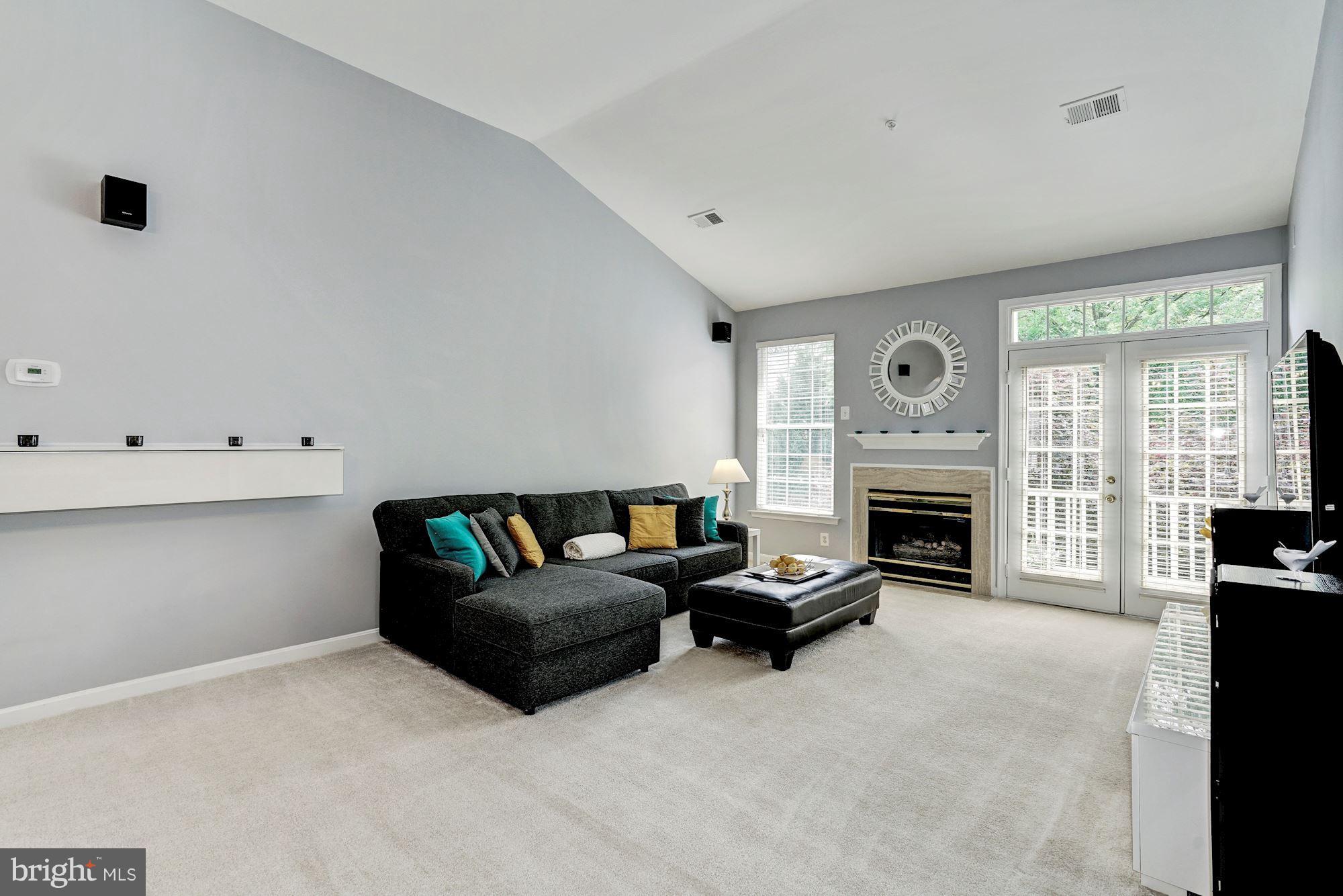 11408 Gate Hill Place, Unit 116 Reston, VA 20194 - Photo 4 of 28 a living room with furniture a fireplace and a flat tv screen