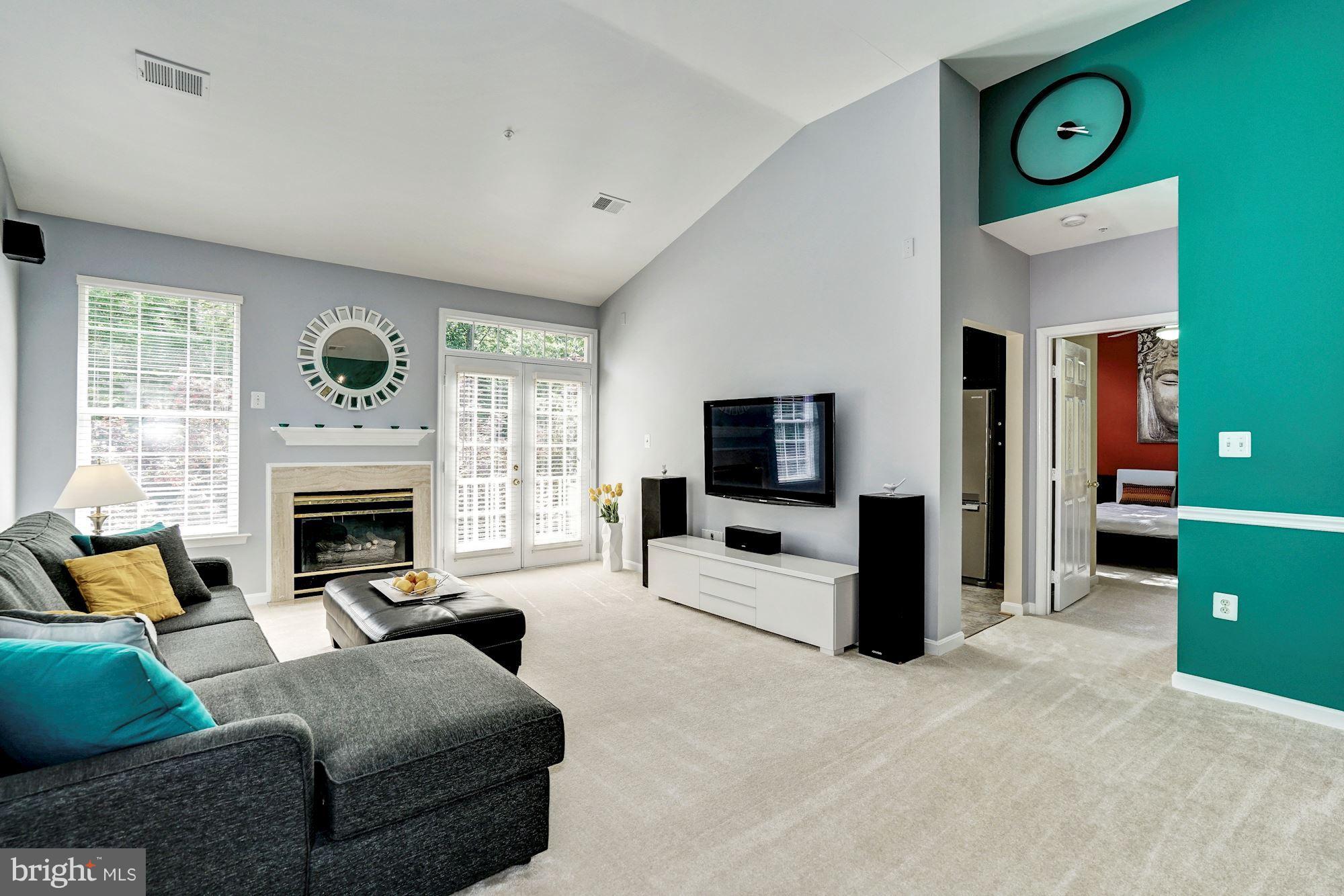 11408 Gate Hill Place, Unit 116 Reston, VA 20194 - Photo 5 of 28 a living room with furniture a flat screen tv and a fireplace