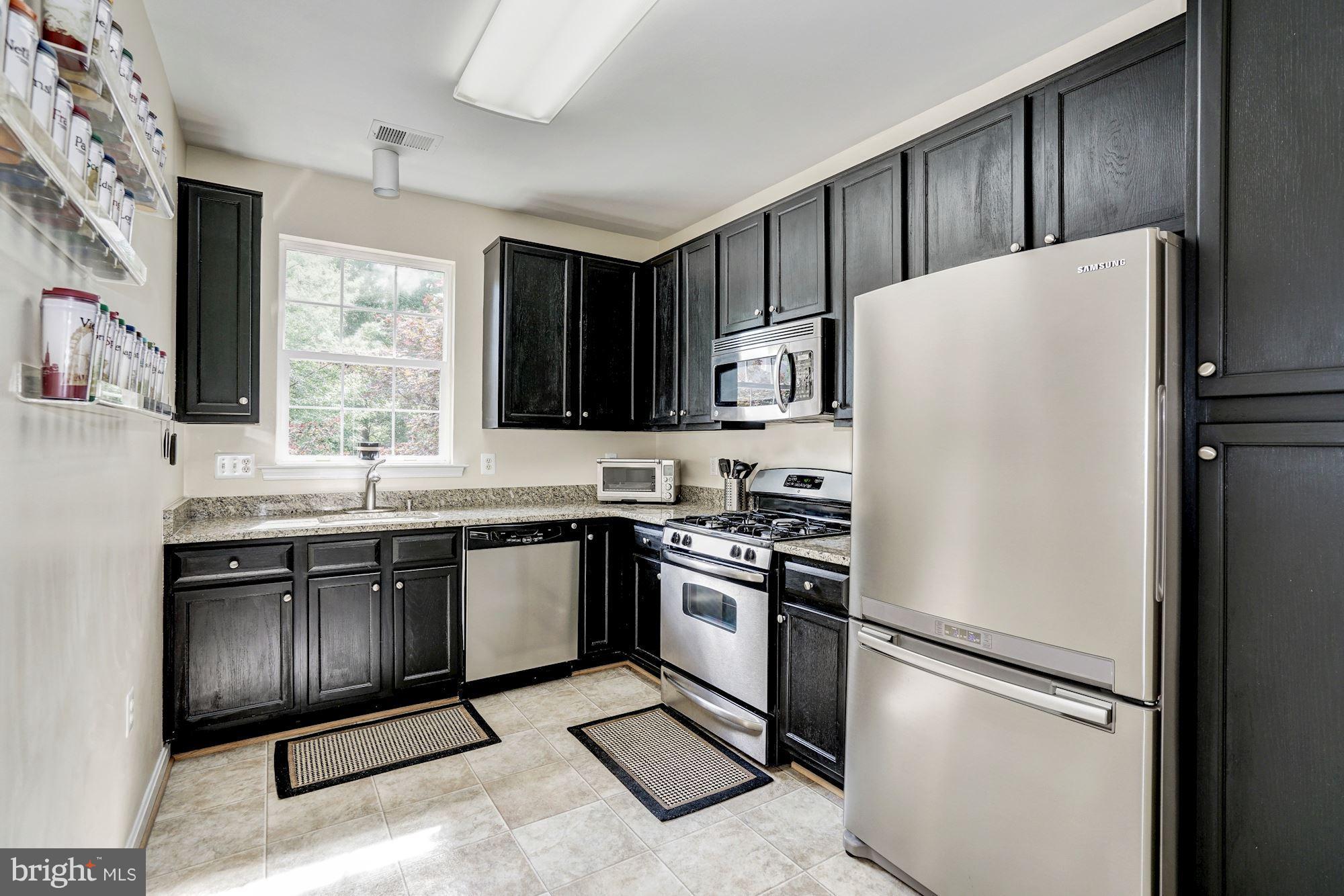 11408 Gate Hill Place, Unit 116 Reston, VA 20194 - Photo 7 of 28 a kitchen with a refrigerator stove and sink