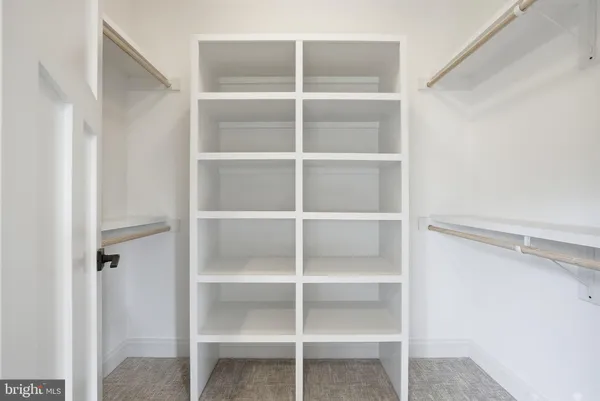 a view of walk in closet with empty racks
