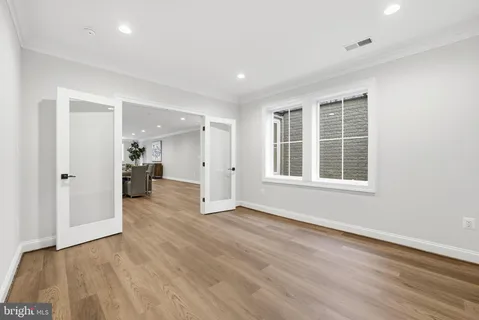 a view of empty room with wooden floor and cabinet