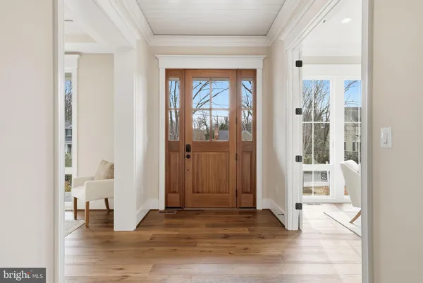 a view of a hallway with wooden floor and a living room
