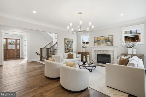 a living room with furniture a chandelier and a fireplace