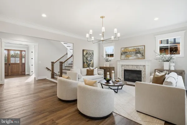 a living room with furniture a chandelier and a fireplace