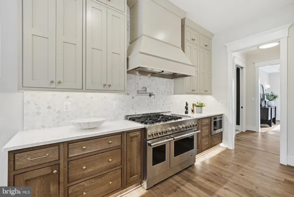 a kitchen with stainless steel appliances granite countertop a stove and a white cabinets
