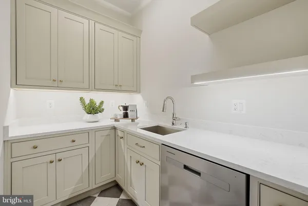 a kitchen with white cabinets and sink