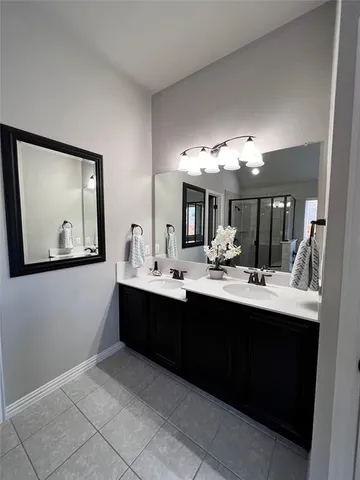 a view with a double vanity sink mirror and cabinets