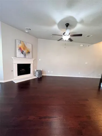 a view of a livingroom with furniture ceiling fan and wooden floor