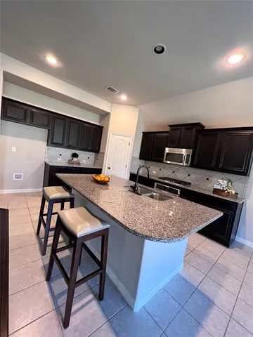 a kitchen with a sink a counter top space appliances and cabinets