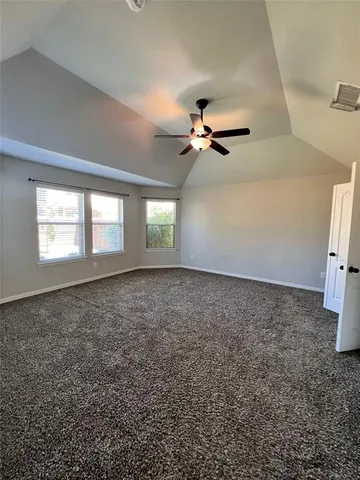 en view of a livingroom with a ceiling fan and window