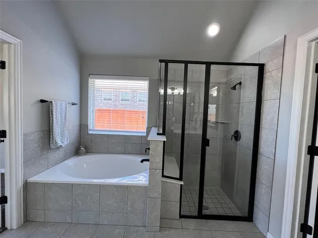 a bathroom with a bathtub a shower and a sink