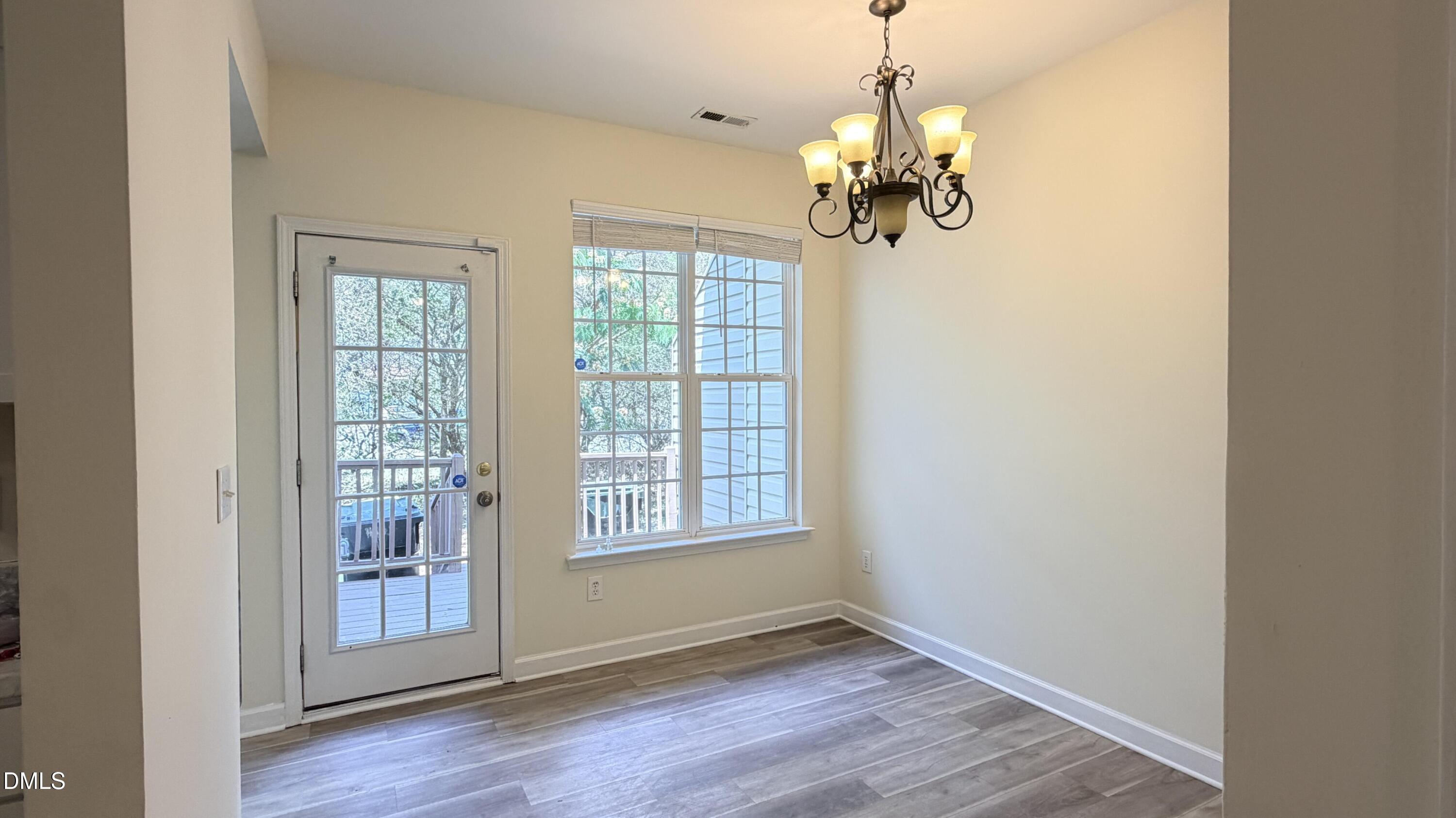 4123 Standing Rock Way Raleigh, NC 27604 - Photo 4 of 29 a view of an empty room with wooden floor and a window