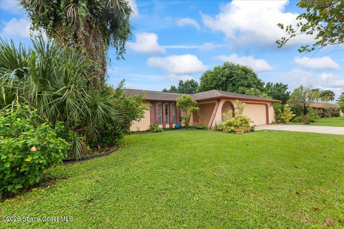 2066 Acacia Street Northeast Palm Bay, FL 32905 - Photo 2 of 28 a front view of a house with a garden