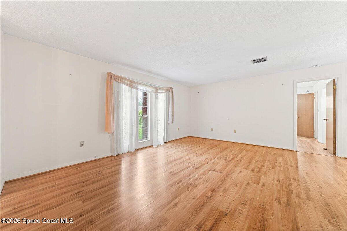 2066 Acacia Street Northeast Palm Bay, FL 32905 - Photo 10 of 28 a view of an empty room with wooden floor and a window
