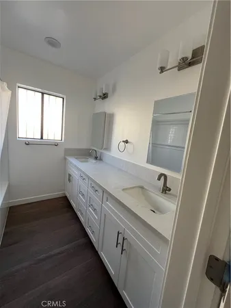 a bathroom with a double vanity sink and mirror