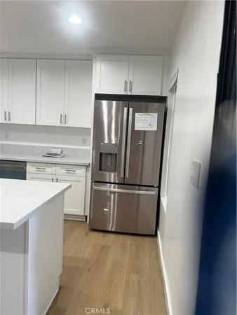 a kitchen with a refrigerator sink and cabinets