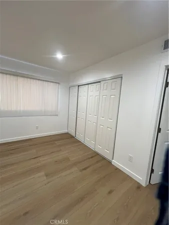 an empty room with wooden floor and window
