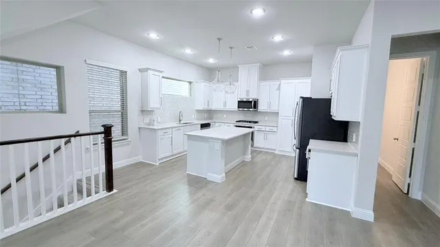 a kitchen with white cabinets and stainless steel appliances