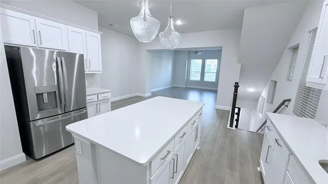 a kitchen with stainless steel appliances a refrigerator a sink a stove and a refrigerator