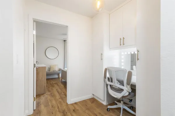 a view of a workspace with furniture and wooden floor