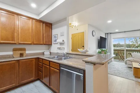 a kitchen with stainless steel appliances granite countertop a sink a stove and cabinets