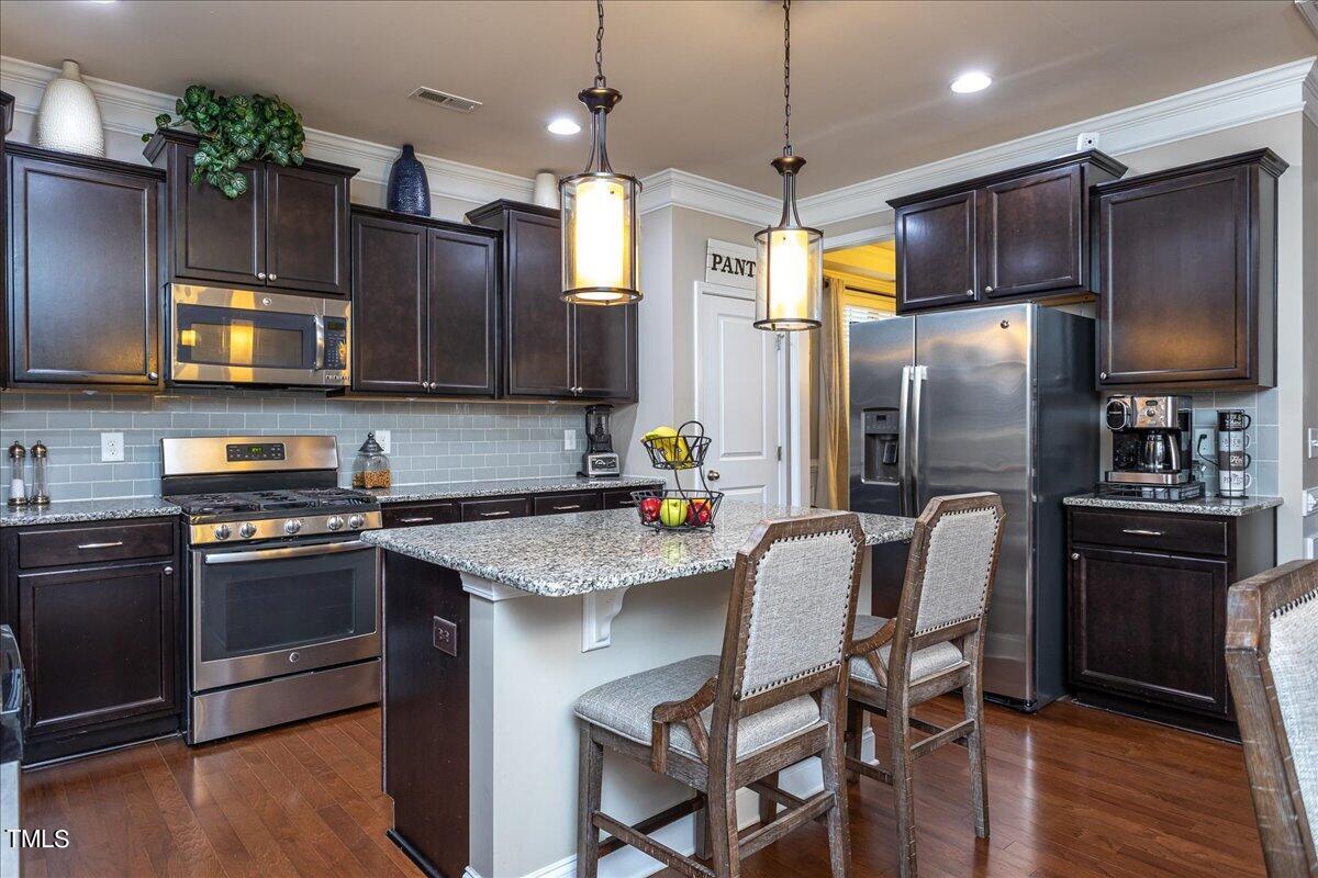 7656 Channery Way Raleigh, NC 27616 - Photo 15 of 44 a kitchen with stainless steel appliances a stove a refrigerator and a microwave