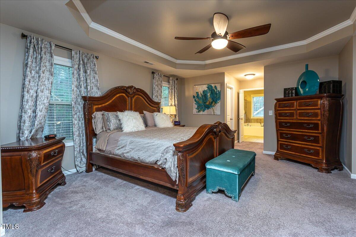 7656 Channery Way Raleigh, NC 27616 - Photo 27 of 44 a bedroom with a bed and a chandelier