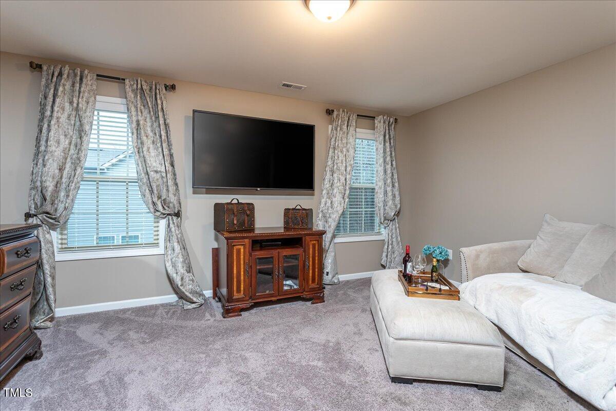 7656 Channery Way Raleigh, NC 27616 - Photo 28 of 44 a living room with furniture and a flat screen tv