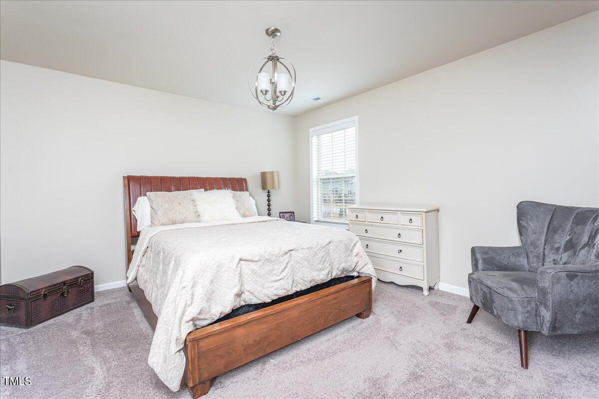 7656 Channery Way Raleigh, NC 27616 - Photo 34 of 44 a spacious bedroom with a bed and a couch