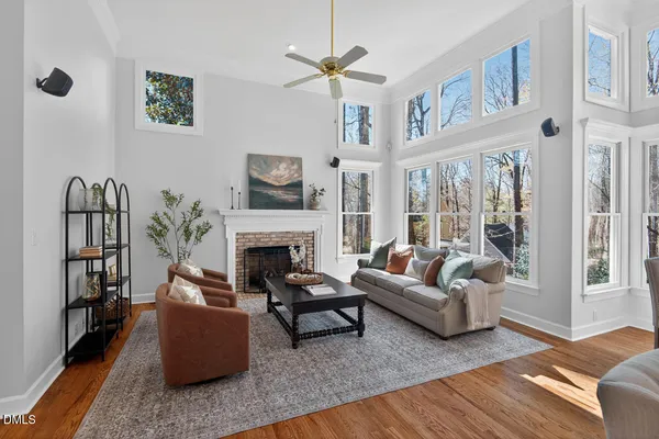 a kitchen with stainless steel appliances granite countertop a refrigerator a stove top oven a dining table and chairs with wooden floor