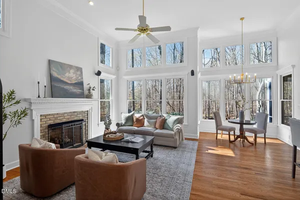 a kitchen with stainless steel appliances granite countertop a refrigerator a sink dishwasher a stove a dining table and chairs with wooden floor