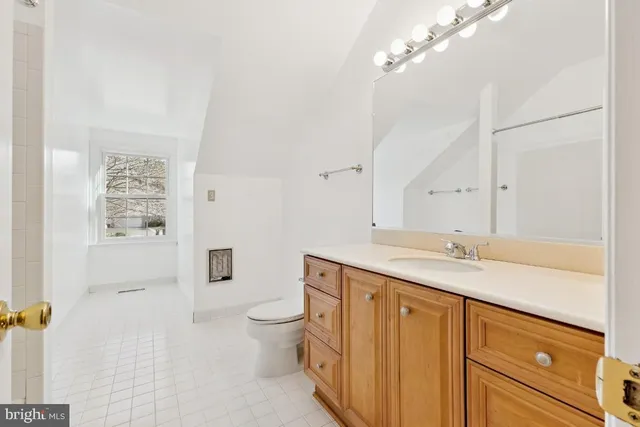 a view of an empty room with wooden floor and a ceiling fan