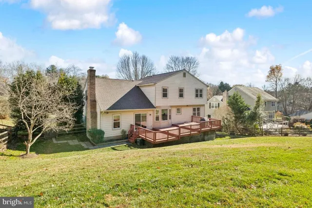 a view of a house with a big yard and potted plants and large trees