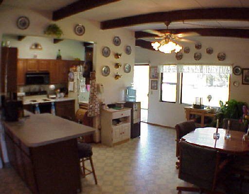 335 Zolezzi Lane Reno, NV 89511 - Photo 2 of 3 a kitchen with stainless steel appliances kitchen island granite countertop a sink dishwasher a dining table and chairs with wooden floor
