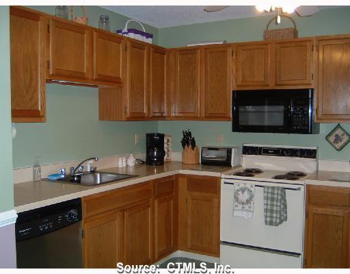 143 Pine Hill Road, Unit 7B Thomaston, CT 06787 - Photo 1 of 1 a kitchen with stainless steel appliances a stove a microwave a sink and cabinets